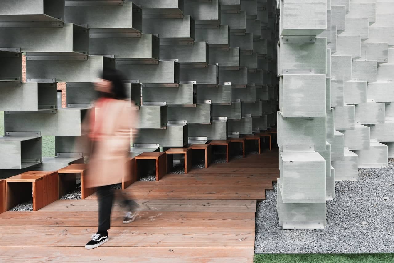 woman walking fast in front of abstract wall