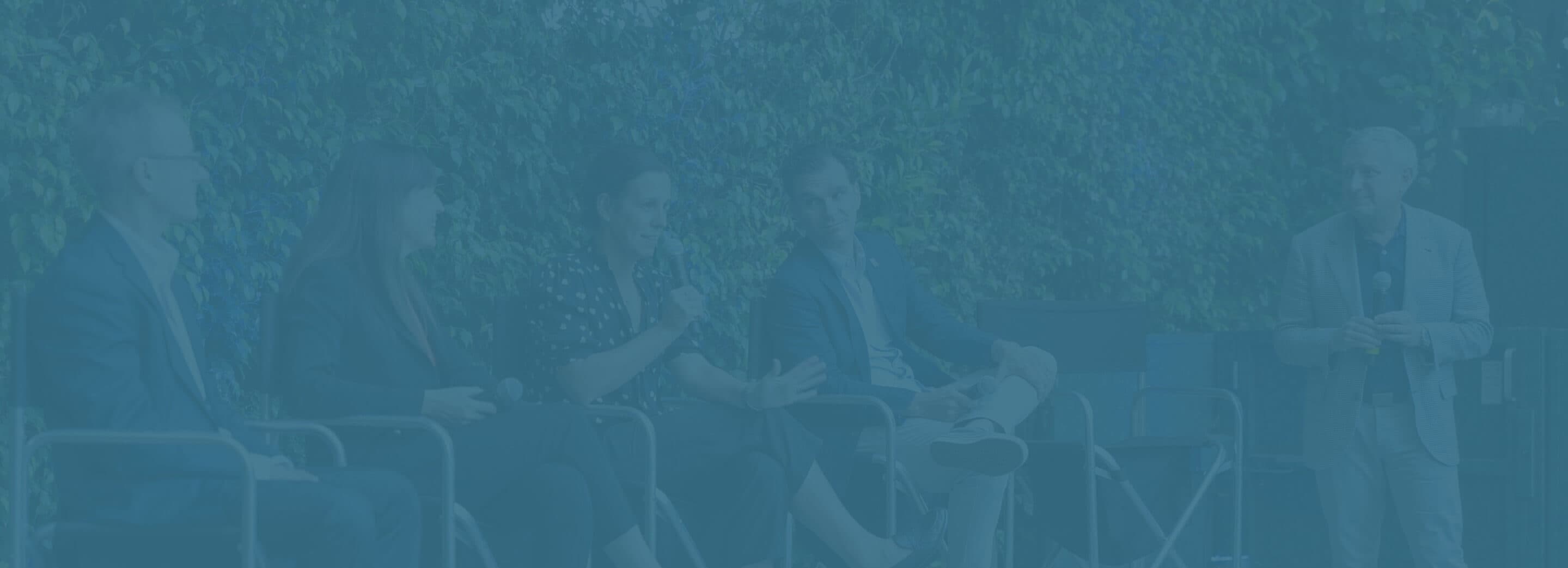 a group of people sitting next to each other speaking for a panel