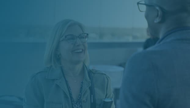 a woman talking to a man wearing glasses