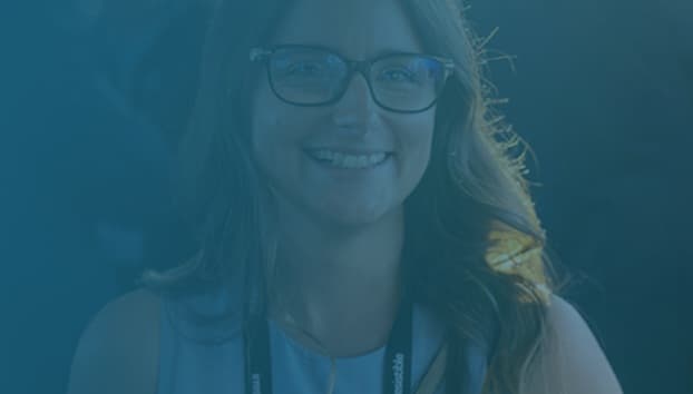 a woman wearing glasses smiling at the camera